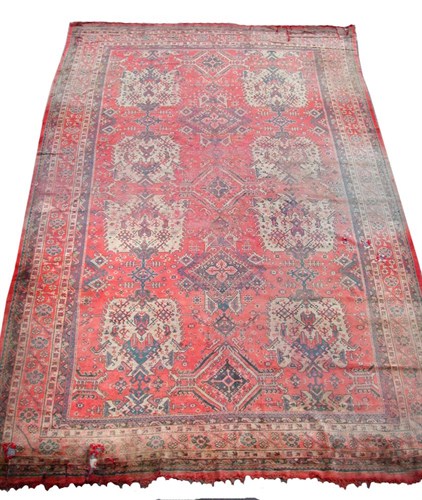 Lot 932 - A large worn and faded turkey carpet