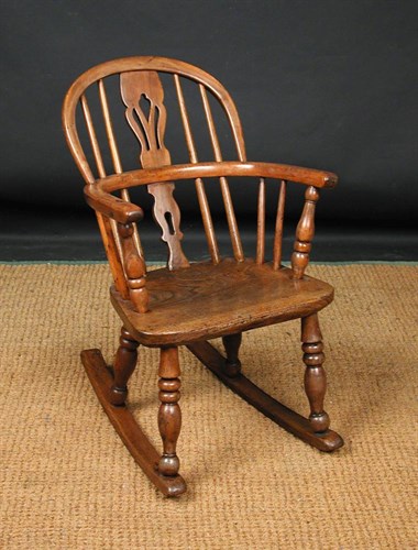 Lot 829 - A 19th century yew wood child's windsor rocking chair