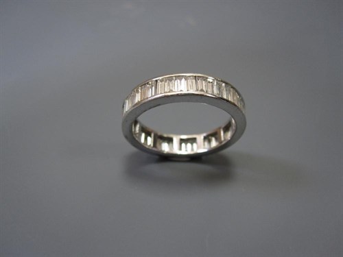 Lot 231 - A baguette cut diamond full hoop eternity ring