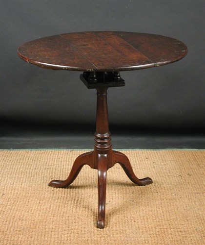 Lot 847 - A George III oak circular tripod table, circa 1760