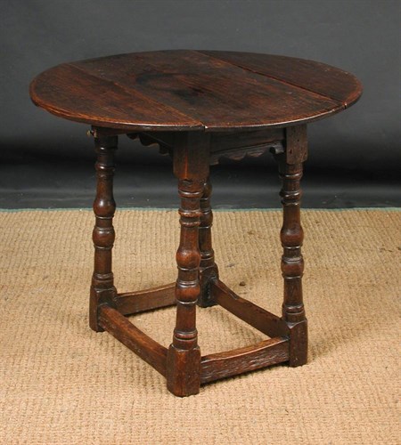 Lot 811 - A charming small 17th century style oak oval drop leaf table