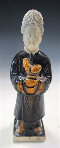 Lot 5 - A Ming pottery figure of a lady, she stands...