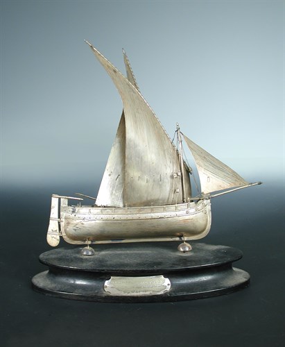 Lot 257 - A white metal model Maltese sailing boat,...