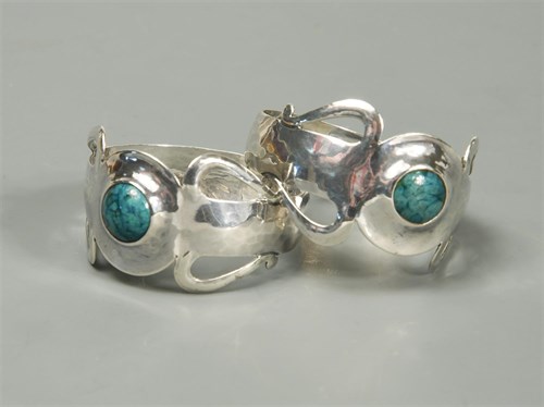 Lot 116 - A pair of Arts & Crafts silver and enamel napkin rings by A. E. Jones