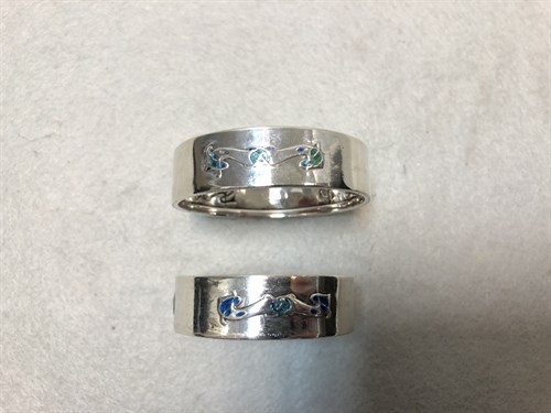 Lot 112 - Liberty & Co., two similar silver and enamel napkin rings