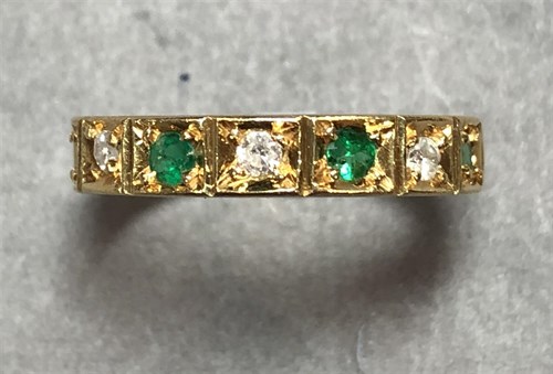 Lot 383 - An emerald and diamond half hoop eternity ring