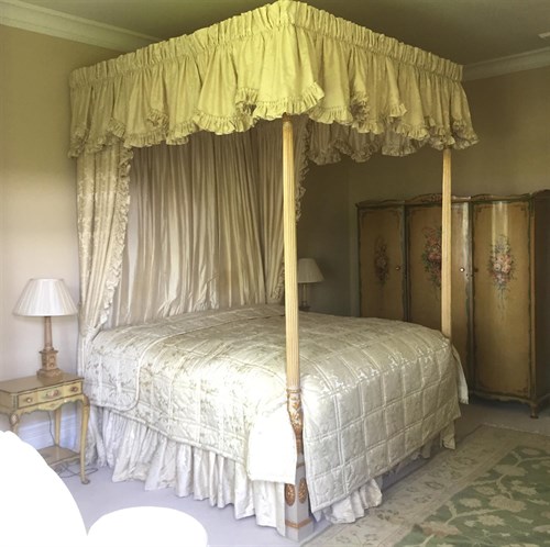 Lot 401 - A George III style painted and parcel gilt four post bed