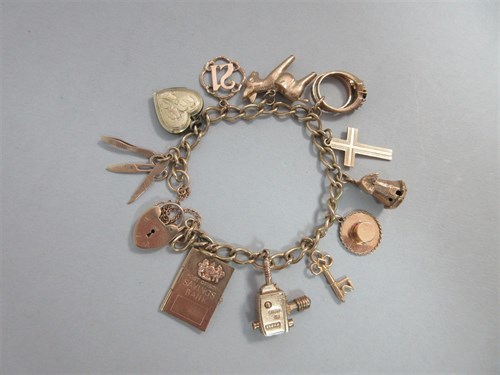 Lot 346 - A gold charm bracelet with many hallmarked charms including a ciné camera and a Post Office Savings Bank book