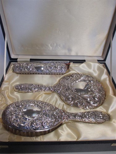 Lot 208 - A cased silver backed four piece dressing...