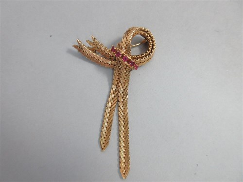 Lot 436 - A mid-20th century ruby and 'ribbon' brooch with French marks for 18ct gold