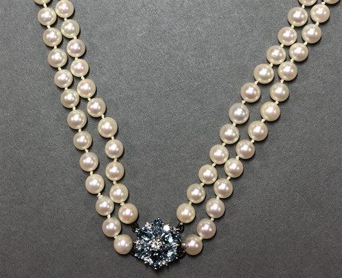Lot 244 - A two row cultured pearl necklace with a diamond and aquamarine cluster clasp set in 18ct white gold