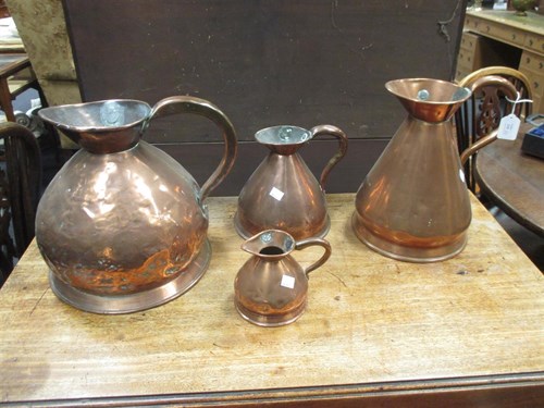 Lot 135 - A collection of 9 copper jugs and a copper...