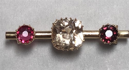 Lot 131 - A three stone bar brooch, the cylindrical bar...