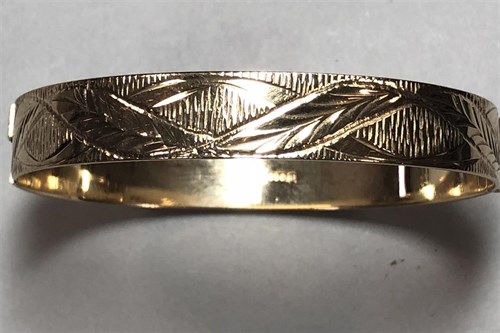 Lot 438 - A 9ct gold engraved hinged bangle