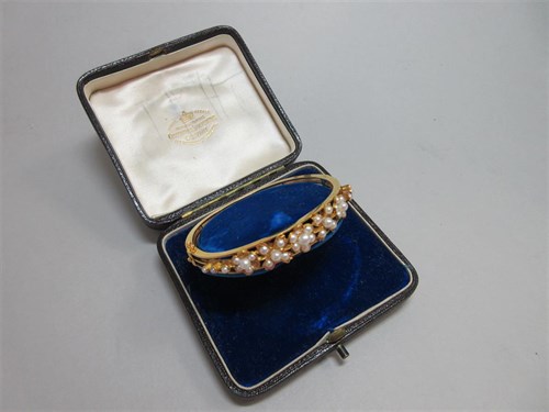 Lot 382 - A seed pearl set hinged bangle