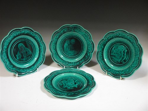 Lot 11 - A set of four green ground majolica plates by...