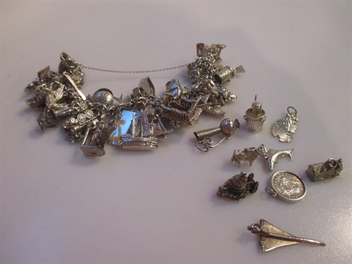 Lot 140 - A silver charm bracelet with about fifty-five...