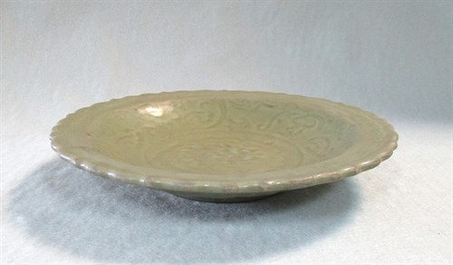 Lot 44 - A Ming dynasty celadon barbed-rim dish