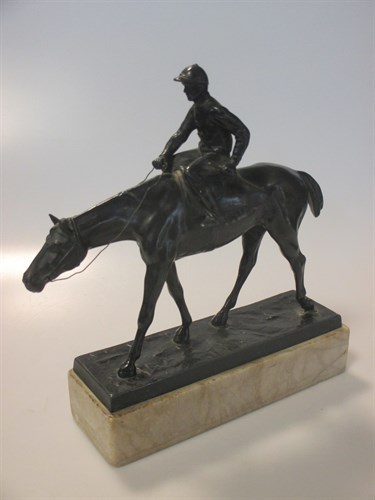 Lot 88 - A bronzed spelter figure of a racehorse with...