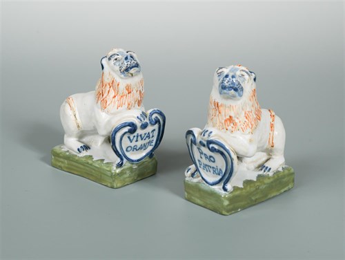 Lot 21 - A pair of  faience pottery lions