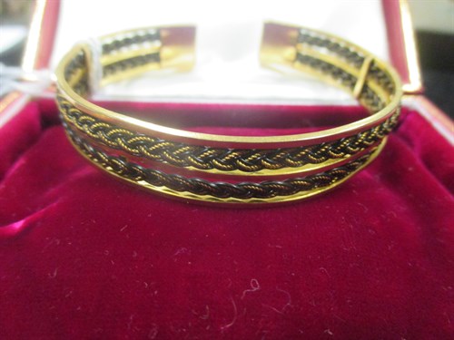 Lot 188 - An unmarked yellow metal torc style bangle,...