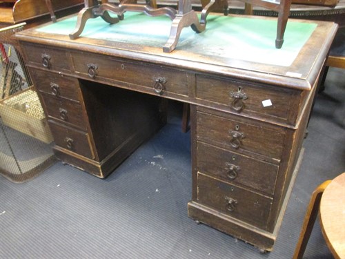Lot 498 - A oak pedestal desk with a green felt top...