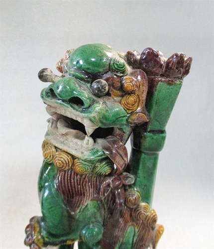 Lot 108 - A pair of Kangxi green, yellow and brown/aubergine glazed buddhistic lion joss stick holders