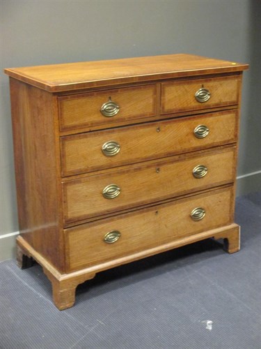 Lot 330 - A George III crossbanded oak chest of drawers,...