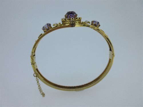 Lot 443 - An amethyst and seed pearl set hinged bangle