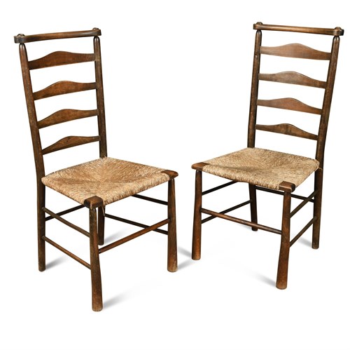 Lot 93 - Attributed to C. R. Ashbee for the Guild of Handicraft, a pair of rush seated ladder back chairs