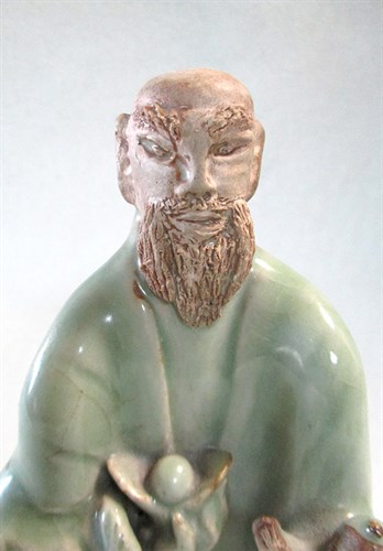 Lot 47 - A Ming dynasty Longquan celadon figure of Fuxing holding a child and an ingot