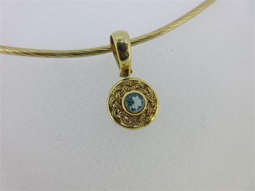 Lot 283 - A twisted wire collar with a blue topaz pendant