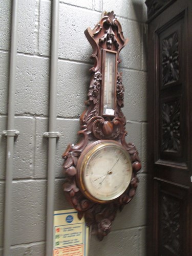 Lot 396 - A late Victorian oak cased barometer carved...