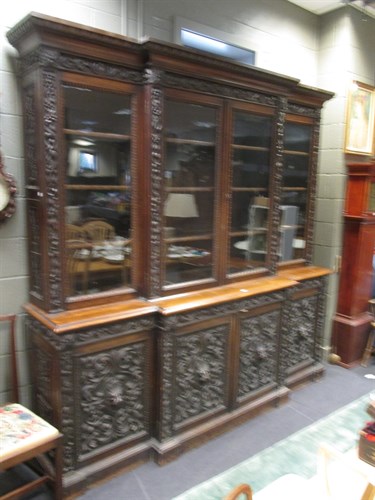 Lot 444 - A Victorian carved oak breakfront glazed...