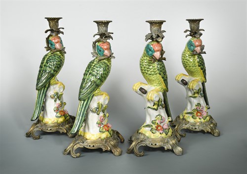 Lot 202 - A set of four gilt metal mounted porcelain parrot candlesticks