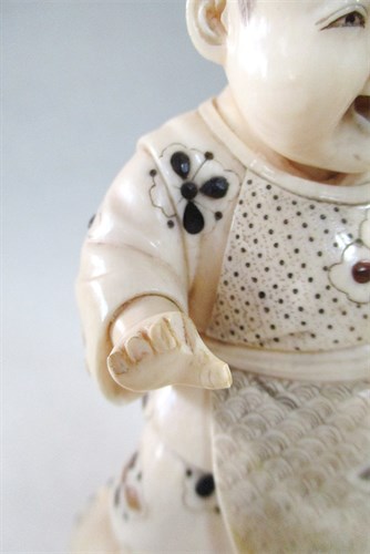 Lot 183 - An okinomo child figure standing on a drum, late Meiji period