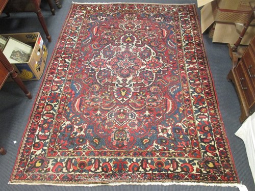 Lot 388 - A Persian red and blue ground rug with central...