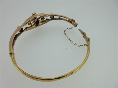 Lot 380 - A pink tourmaline and seed pearl hinged bangle