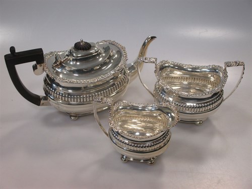 Lot 284 - A silver three piece tea set with gadrooned...