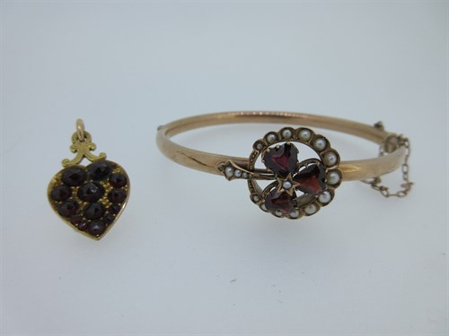 Lot 74 - A garnet and seed pearl shamrock bangle and a garnet set gold heart pendant