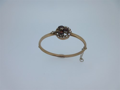 Lot 74 - A garnet and seed pearl shamrock bangle and a garnet set gold heart pendant