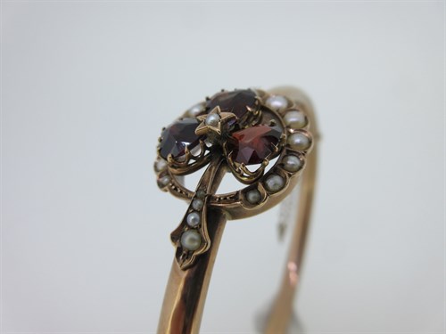 Lot 74 - A garnet and seed pearl shamrock bangle and a garnet set gold heart pendant