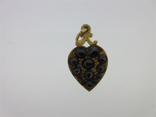Lot 74 - A garnet and seed pearl shamrock bangle and a garnet set gold heart pendant