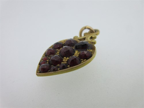 Lot 74 - A garnet and seed pearl shamrock bangle and a garnet set gold heart pendant
