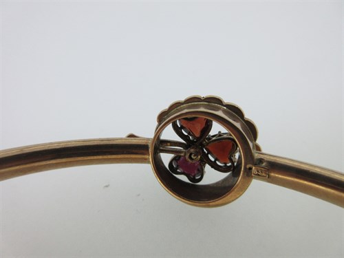 Lot 74 - A garnet and seed pearl shamrock bangle and a garnet set gold heart pendant