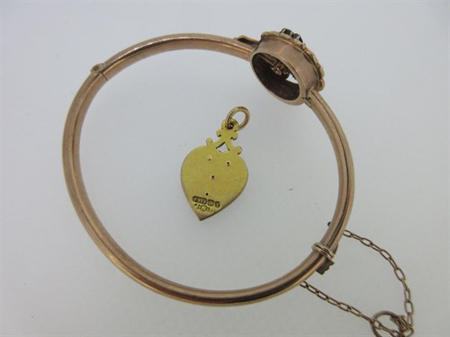Lot 74 - A garnet and seed pearl shamrock bangle and a garnet set gold heart pendant