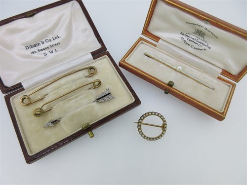 Lot 12 - A diamond and onyx jabot pin designed as an arrow together with four other brooches or pins