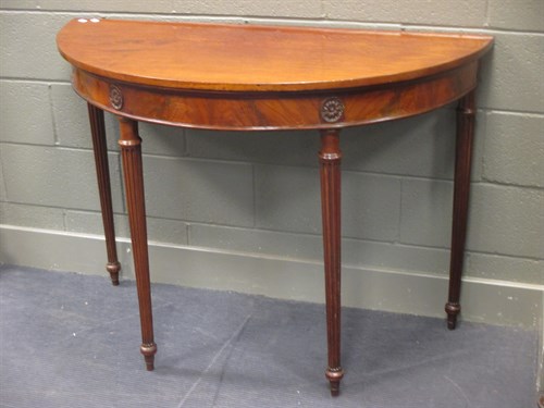 Lot 381 - A mahogany demi-lune pier table on reeded legs...