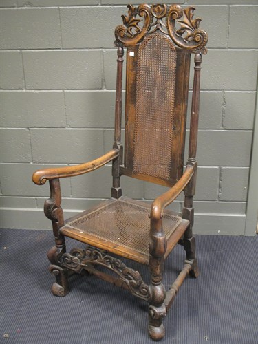 Lot 454 - A Carolean style carved oak open arm elbow chair