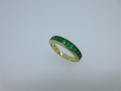 Lot 238 - Garrard & Co - An 18ct gold and emerald half hoop eternity ring